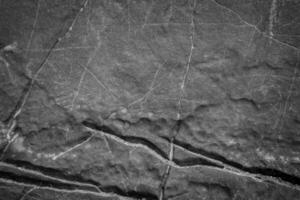 Close-Up of Natural Stone Surface with Intricate Cracks and Textures in Black and White photo