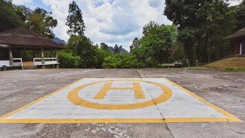 Helipad in Scenic Forest Setting with Lush Greenery and Cloudy Sky in the Background photo