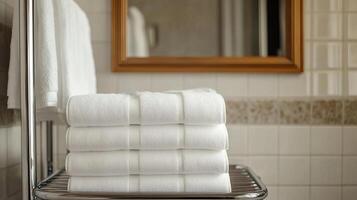 A stack of white towels on a bathroom shelf photo