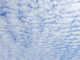 A plane flying in the sky with some clouds photo