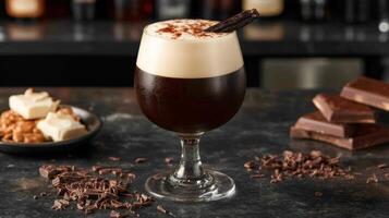rich vanilla stout in snifter glass with dark body and velvety head, garnished with vanilla bean and chocolate shavings, in dimly lit bar setting photo