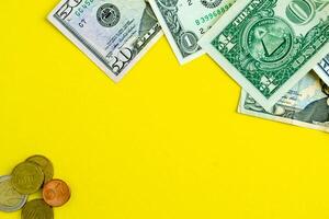 Dollars and euro coins on a yellow background, background with copy space. photo