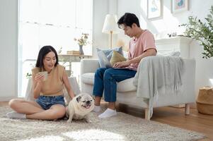 Couple Enjoys Leisure Time at Home With Their Pet Dog While Using a Laptop in a Cozy Living Room photo
