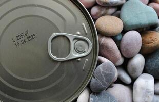 Canned Meat Conserve With Stamped Expiration Date Of 2029 Over Sea Pebbles photo