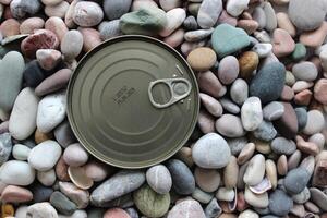 The top of the tin can is flush with the surface of the pebbles copy space image photo