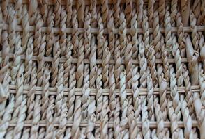 Handmade craft. Texture of thin wooden twigs woven in braids photo