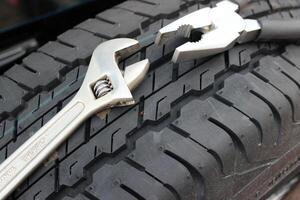 Pliers And Adjustable Wrench On A Spare Car Tire photo