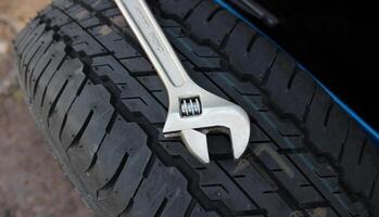 Chrome adjusting wrench lie on the spare wheel attached to the trunk door of the SUV car photo