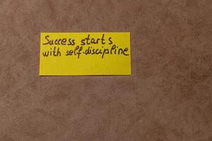 Success starts with self-discipline message on yellow sticky note photo