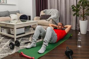 Man doing sit-ups at home during workout session photo