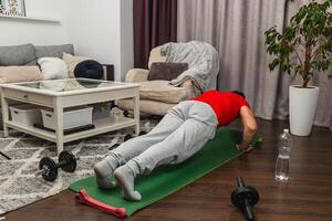 Man exercising indoors with push-ups on a mat photo