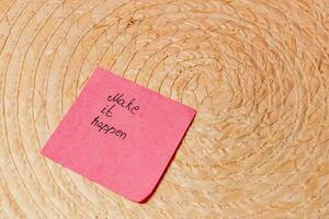 Motivational message on sticky note placed on a woven surface photo