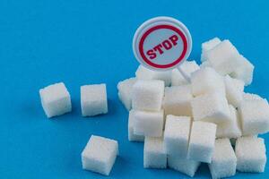 Awareness campaign against sugar consumption with sugar cubes and sign photo