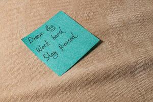 Motivational sticky note encouraging focus and hard work on a soft surface photo