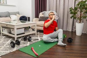 Man exercising at home while staying hydrated photo