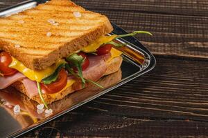 Homemade double grilled cheese sandwich with ham, spinach, and arugula photo