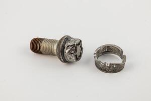 Broken bolt and wheel component lying on a surface photo