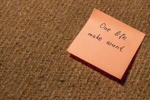 Motivational sticky note with inspiring message on textured surface photo