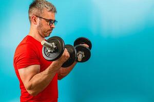Man lifting dumbbells for strength training in gym photo