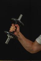 Weightlifting exercise in the gym with a dumbbell photo
