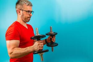 Man lifting dumbbells in bright workout setting photo