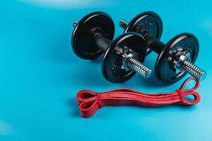 Weights and resistance bands arranged on a blue background photo