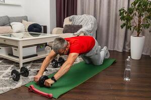 Man training with ab roller in living room photo