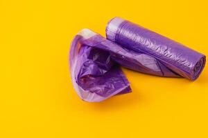 Purple plastic rolls displayed on a bright yellow background photo