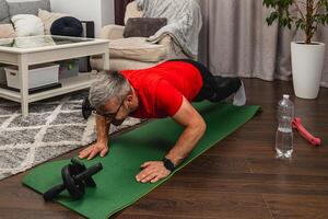Man exercising at home with push-ups on mat photo