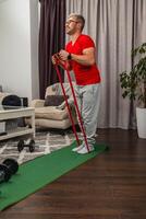 Man exercising with resistance bands in living room photo