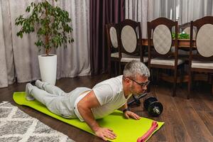 Man exercises at home using a fitness mat photo