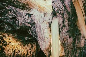A waterfall in a cave with a long line of water photo