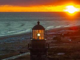 A lighthouse with a light shining in the sky photo