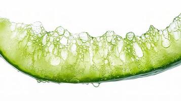 A slice of cucumber is being splashed with water photo