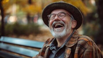 An older man laughing on a park bench photo