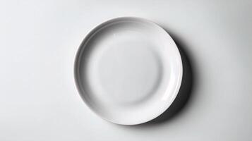 An empty white plate on a white surface photo