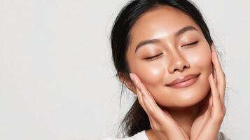 A woman with her eyes closed and her hands on her face photo