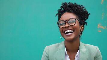 A smiling black woman wearing glasses and a green shirt photo