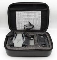 A gray drone and remote control are neatly arranged inside a black protective case. photo