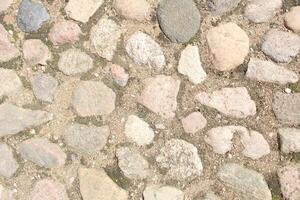 Stone background of cobblestones. An old paved stone road. Brutal background photo