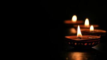 Diya oil lamps against dark background. Warm and inviting Diwali mood. Copy place photo