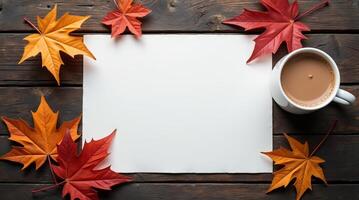 Colorful autumn maple leaves and a cup of coffee placed beside blank paper on rustic wood surface, perfect for seasonal or cozy concepts photo