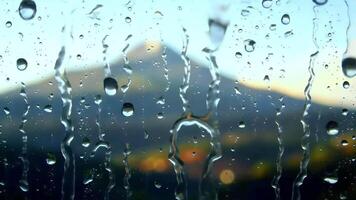 raining on window with mountain view video