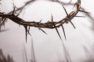 Jesus Crown thorns casting a distinct shadow on a for Christian background, Easter concept creating a symbolic image of suffering, sacrifice, and remembrance Copy space for text photo