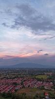 Vertical footage, Timelapse sunset over a suburban area with a vibrant sky and distant mountains, viewed from an elevated perspective. video