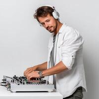 DJ standing the console with headphones on listening to music and enjoying in white background photo