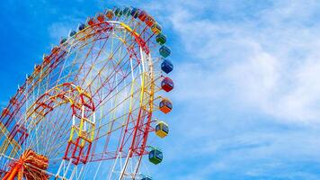 A fragment of a Ferris wheel against the sky in an amusement park. Panoramic view photo