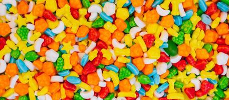 Panoramic background of assorted colorful candies. View from above. photo
