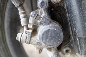 Close up of dusty motorcycle brake caliper part photo