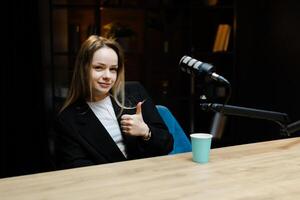Radio host gesturing thumbs up during a podcast recording photo